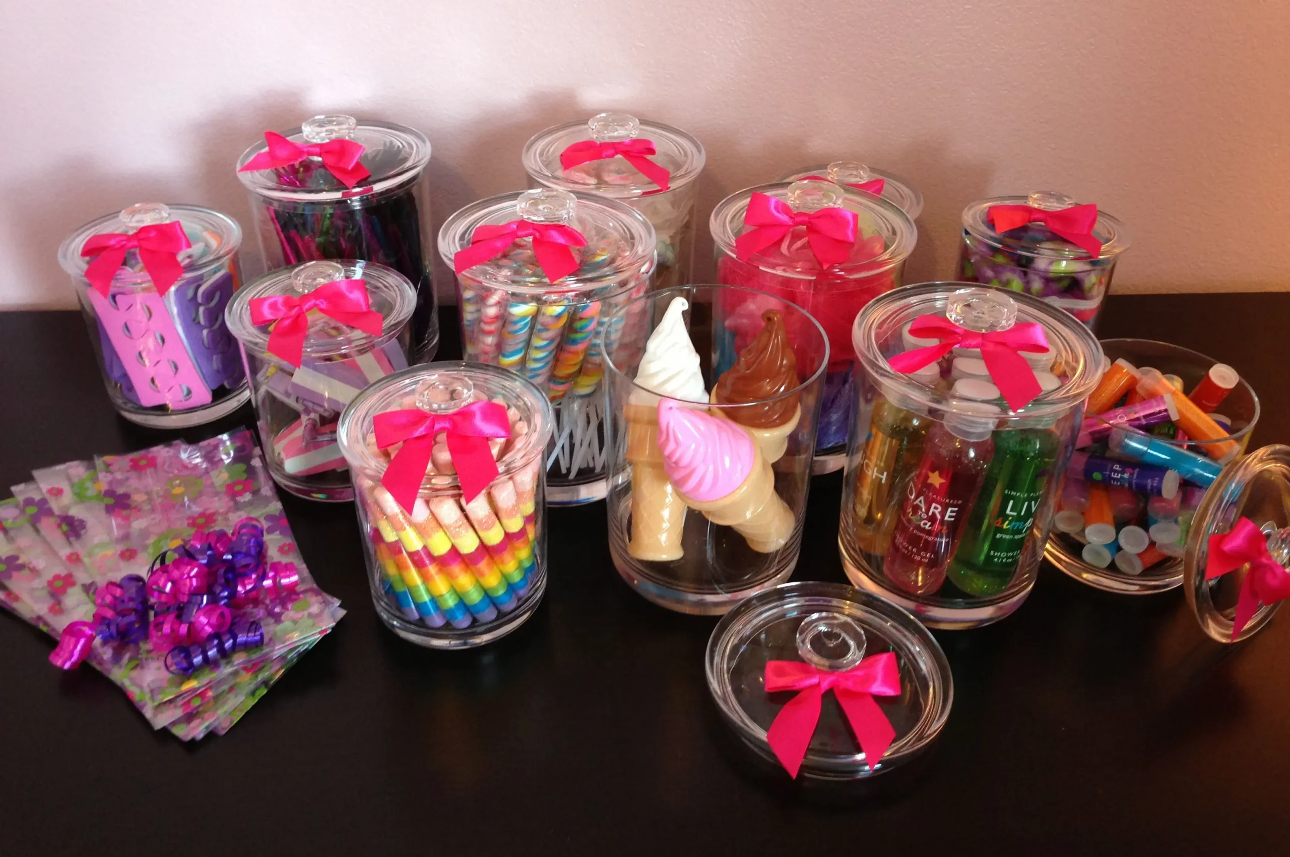 Glass jars filled with colorful spa goodies, accessories, and pamper treats for Feel Fabulous Kids Spa goody bags