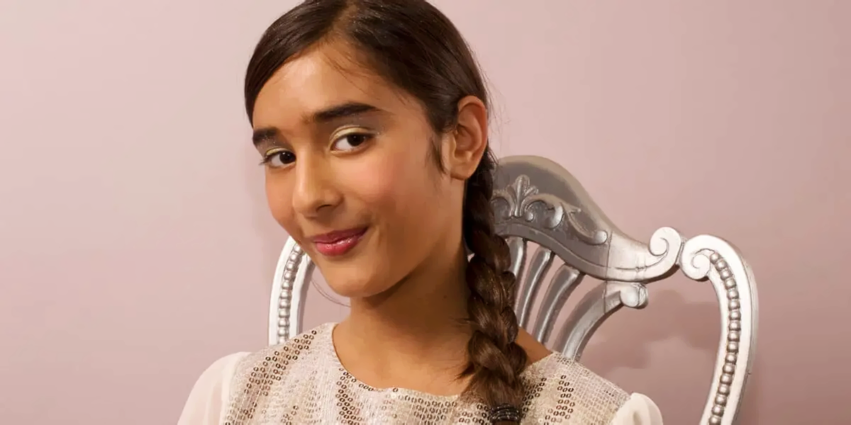 Young girl with braided hair and soft glam makeup smiling during a pamper party session at Feel Fabulous Kids Spa.