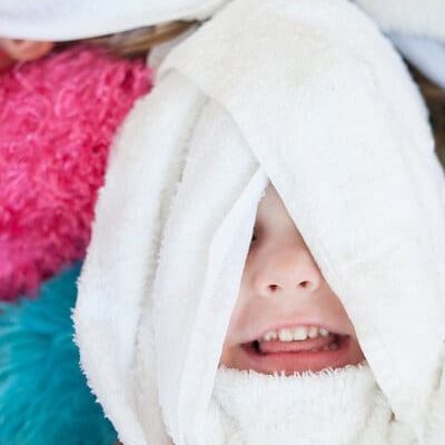 Little girl with towel on the face enjoying spa treatment